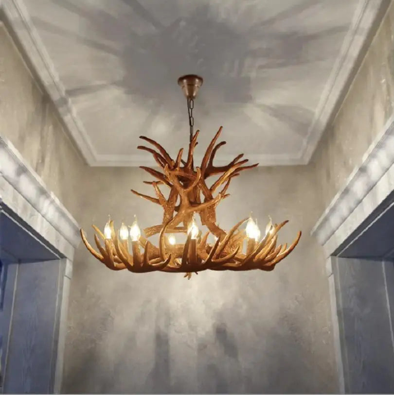 Antler-style chandelier hanging in a room with a decorative ceiling.