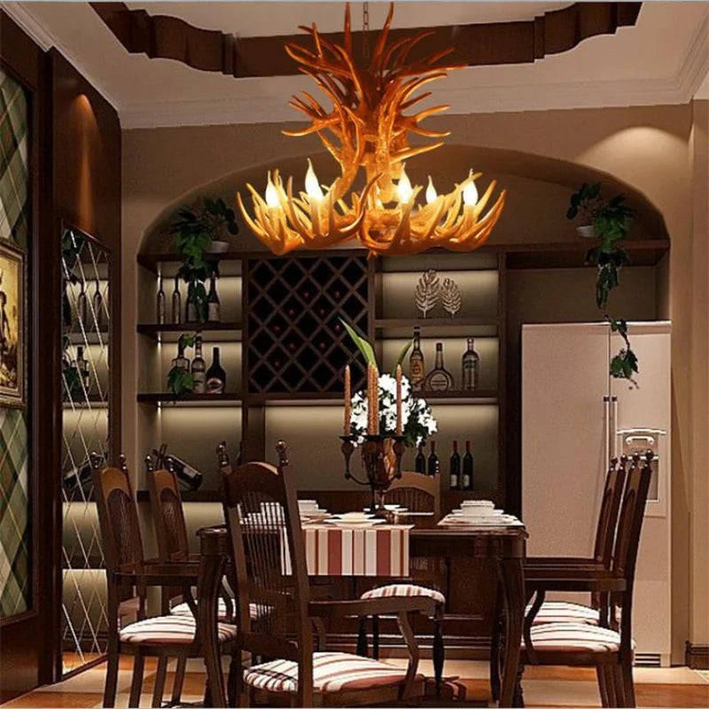 Dining room with a large antler chandelier, wooden table, and chairs.