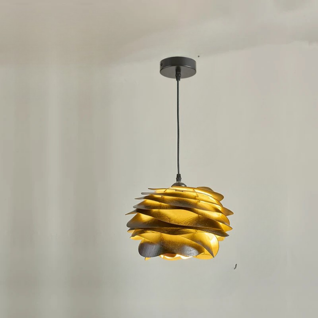Gold pendant light fixture hanging against a plain background