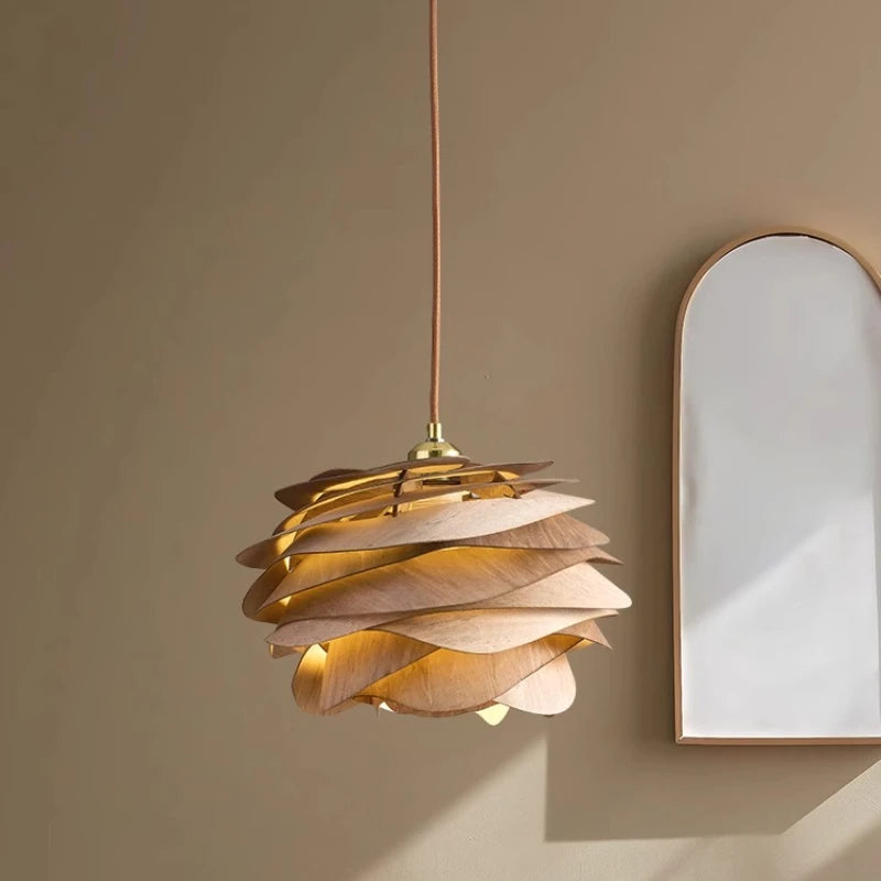 Gold pendant light fixture on a beige wall with a mirror
