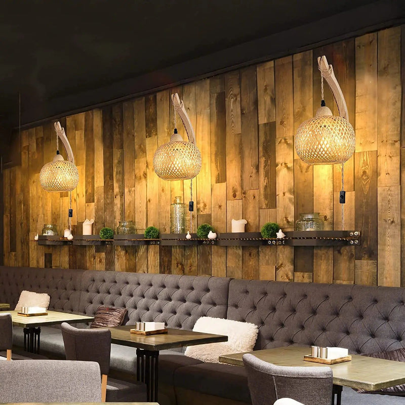 Interior of a restaurant with wooden wall, gray booth seating, and hanging lights.