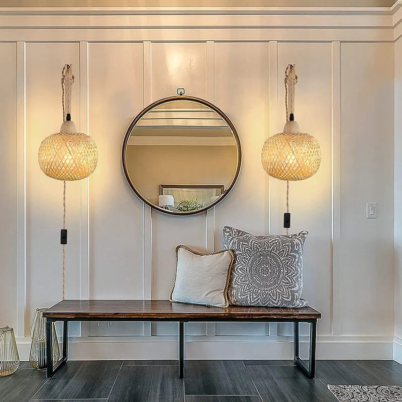 Modern entryway with round mirror, wooden bench, and decorative pillows.