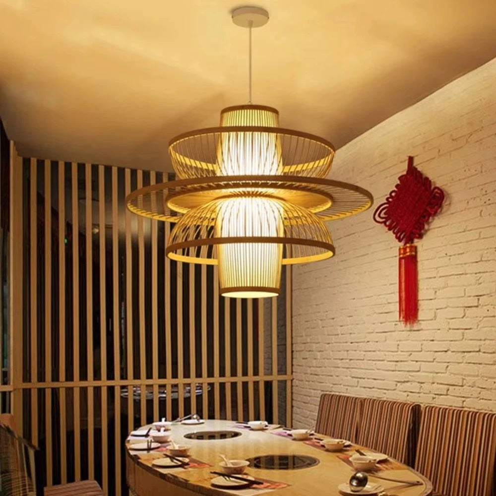 Modern restaurant interior with a stylish chandelier, dining table, and decorative wall hanging.