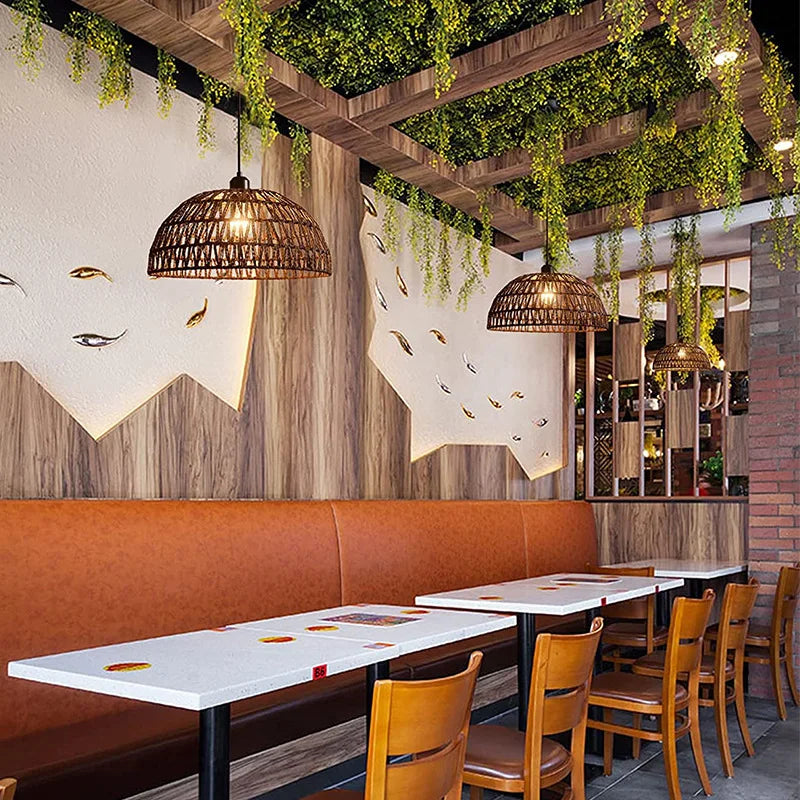 Modern restaurant interior with orange booth, wooden chairs, and hanging plants.