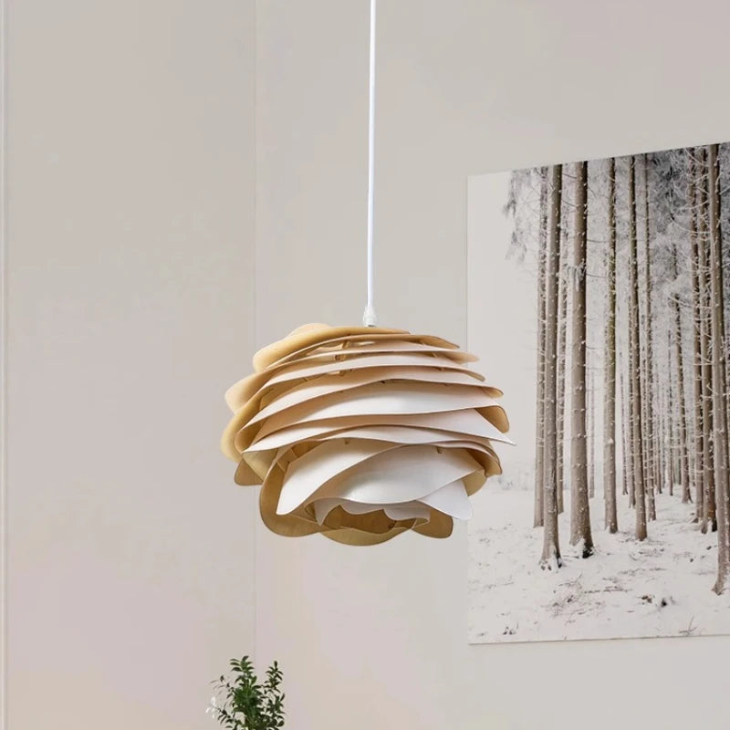 Wooden pendant light hanging against a wall with a forest print