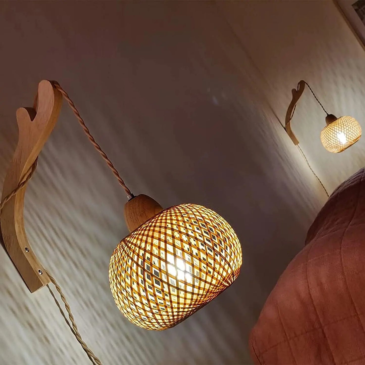 Woven pendant light fixture with wooden arm on a neutral wall.