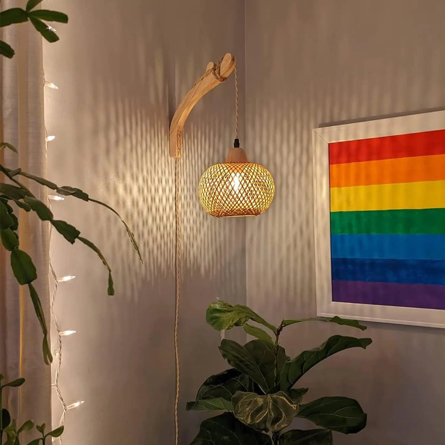 Woven pendant light hanging on a wall with a rainbow flag in the background