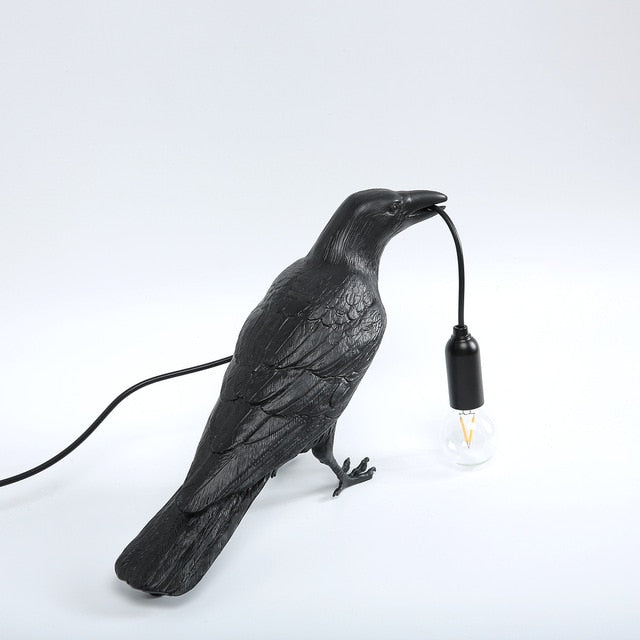 crow holding light bulb lamp