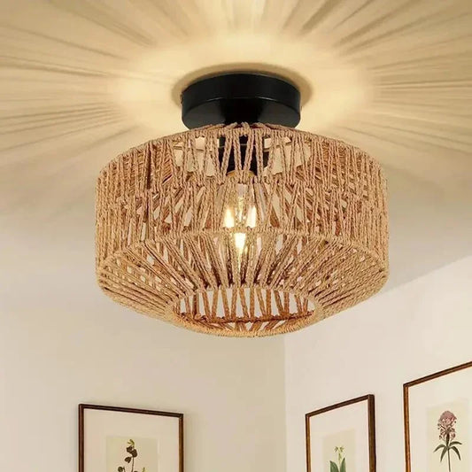 Ceiling light fixture with woven design on a wall with framed pictures.