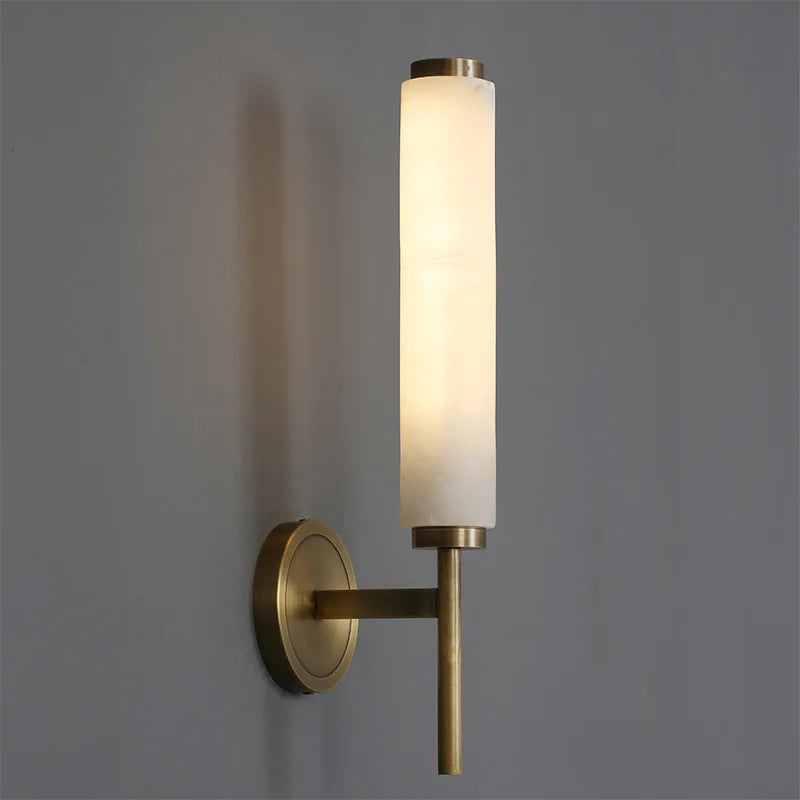 Close-up of Deanley modern wall sconce with frosted glass and brass finish mounted on interior wall