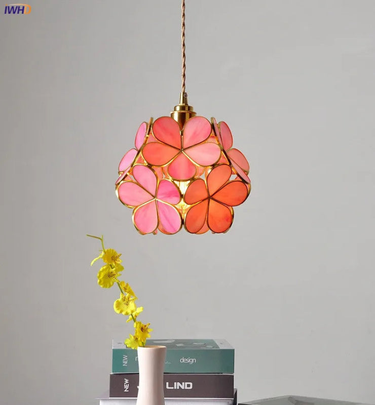 Decorative pendant light with pink floral design on a gray background
