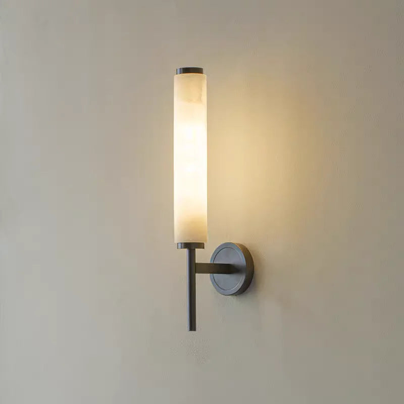 Minimalist marble wall sconce with cylindrical glass shade for bedroom or hallway lighting