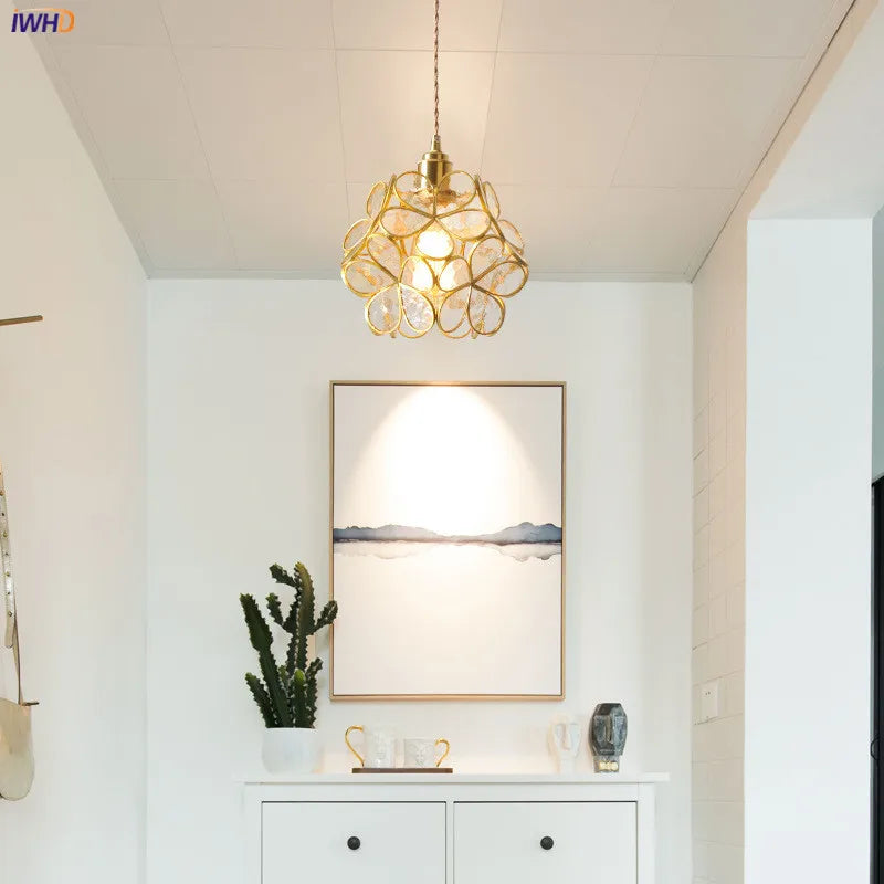 Modern interior design with a gold pendant light, framed artwork, and decorative items.
