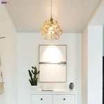 Modern interior design with a gold pendant light, framed artwork, and decorative items.