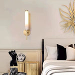 Modern vertical wall lamp in brushed brass with warm ambient glow