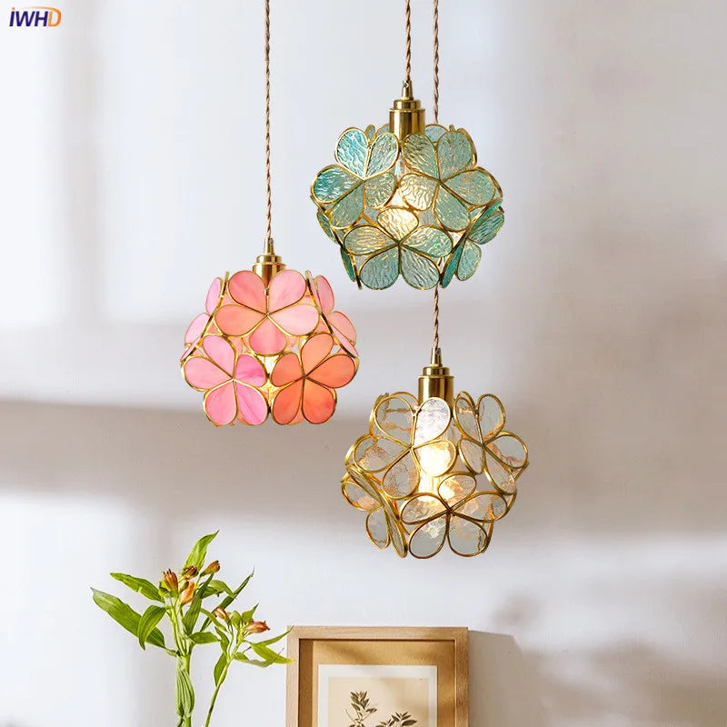 Three decorative pendant lights with floral designs on a neutral background
