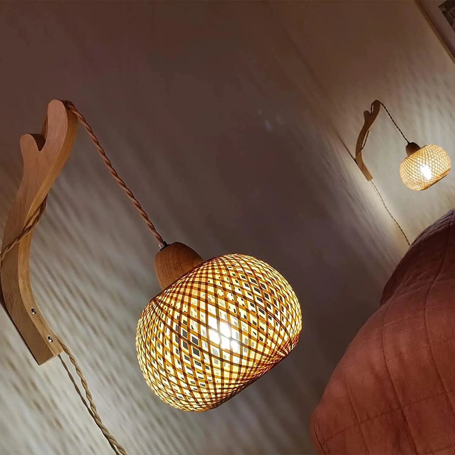 Woven pendant light fixture with wooden arm on a neutral wall.