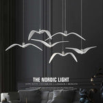 Bird wing chandelier illuminated in dark interior