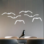 Modern Bird Wing Chandelier hanging above dining table