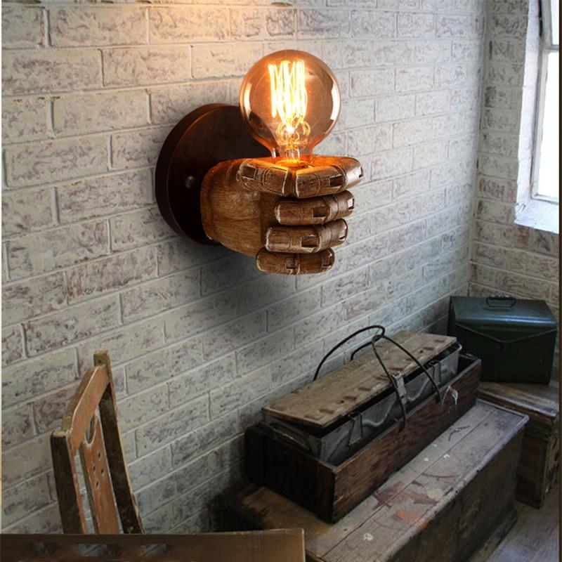 hand-shaped wall lamp holding light bulb